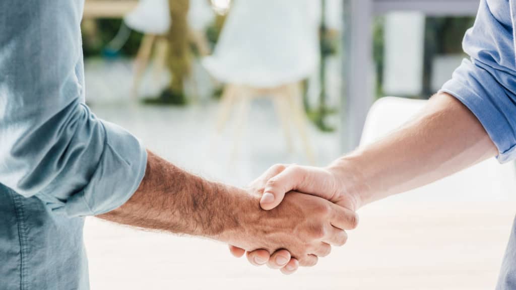 Image of men shaking hands together